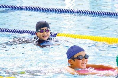 写真：ビート板を使って泳ぐ児童たち
