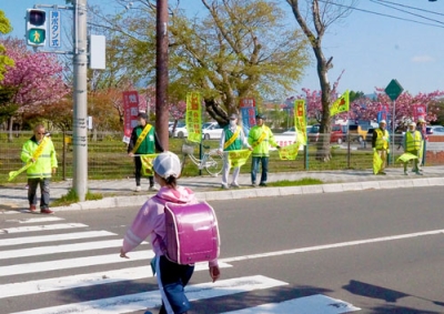 写真：横断歩道を渡る児童の安全を見守る参加者