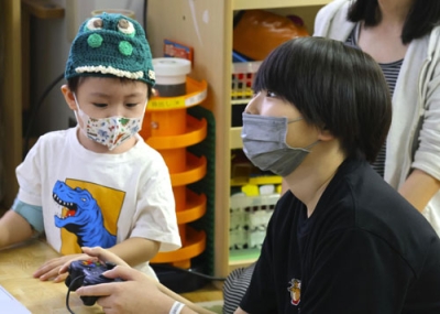 写真：アバター（分身）ロボットを操作して博物館の恐竜展示を見る入院中の子どもたち＝札幌市
