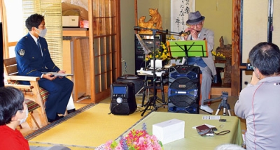 写真：ハーモニカで懐かしのメロディーを奏でる佐々木さん