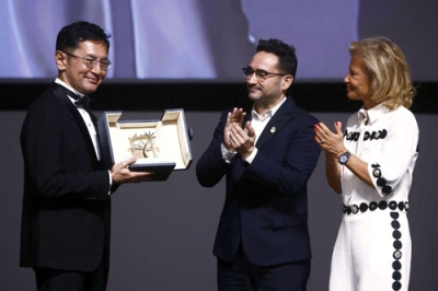 写真：カンヌ国際映画祭でスタジオジブリが「名誉パルムドール」を受賞し、トロフィーを受け取った宮崎吾朗監督（左）＝２０日、フランス・カンヌ（ロイター＝共同）