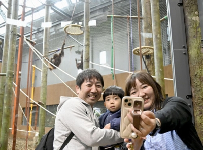 写真：新たな飼育施設でオランウータンと写真を撮る来園者＝２１日午前、札幌市の円山動物園