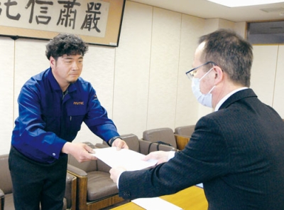 写真：請願書を提出する田上副代表（左）