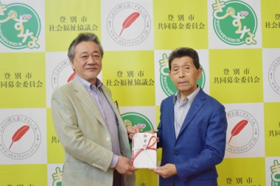 写真：登別市社協の仲川会長（左）に寄付金を手渡す斉藤会長（提供写真）