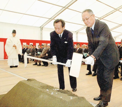写真：むろらん広域センタービルの起工式でくわ入れを行う天里氏（左）＝２００８年３月