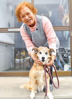 写真：町民らの協力プレーで、壮瞥穴から救助されたタッキーと感謝する飼い主の豊子さん