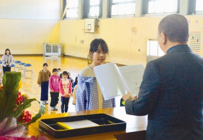 写真：校長から修了証書を受け取る児童