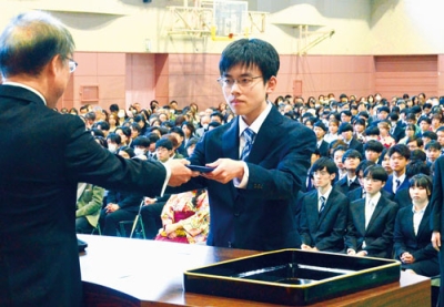 写真：松田学長から学位記を受け取る学科代表の卒業生