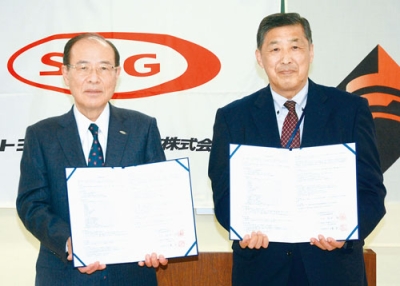 写真：契約書に署名した（左から）千葉社長と福井校長