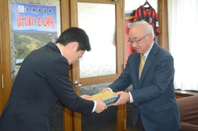 写真：大塩町長に「白老町史（平成版）」を手渡す白崎委員長（右）