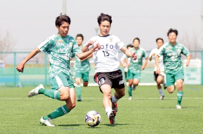 写真：【大谷室蘭高－北海高】後半、ドリブルで持ち上がる大谷室蘭・髙橋（中央）＝リーフラスフットボールパーク