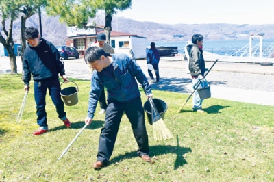 写真：湖畔周辺でごみを拾う参加者