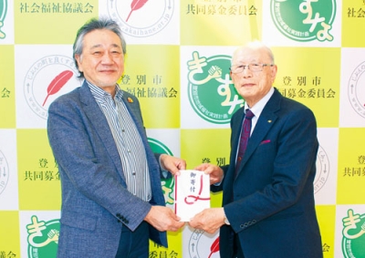 写真：仲川会長（左）へ目録を手渡す佐藤さん（提供写真）