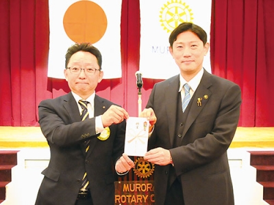 写真：青山市長に図書カードを手渡す平林会長代行（左）