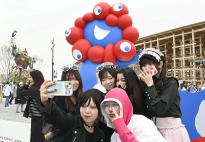 写真：ミャクミャク像の前で撮影する来場者＝１８日、大阪市此花区の夢洲