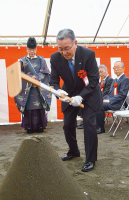 写真：くわ入れを行う高橋代表取締役社長