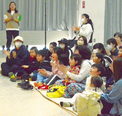 写真：笑顔で演劇を鑑賞する会員たち