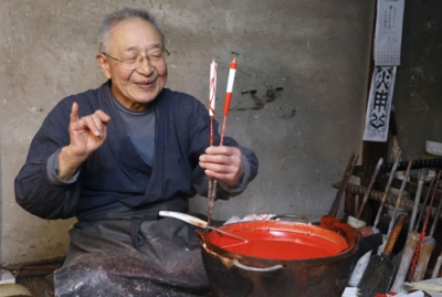 写真：「現代ろうそく」について説明する三嶋順二さん＝１月、岐阜県飛騨市