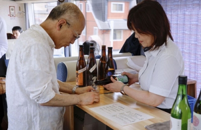 写真：信州地酒トレインで日本酒を注文する乗客＝長野県内