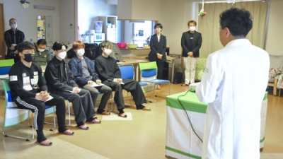 写真：特別養護老人ホームで関係者から説明を受ける柴田尊文（左端）らグリーンツダジムのボクサー＝４月、大阪市浪速区