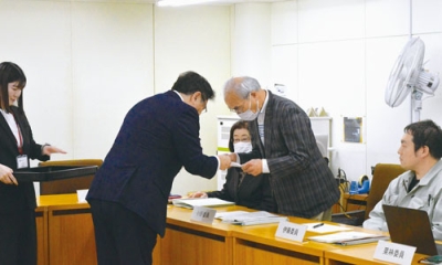 写真：小笠原市長から委嘱状を受け取る委員（右）