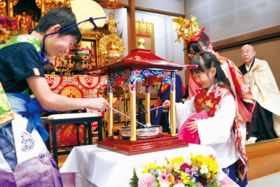 写真：釈迦像に甘茶を注ぐ子ども