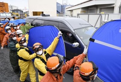 写真：下水道管内の捜索で発見された男性運転手とみられる遺体を乗せ、県道陥没事故の現場を離れる車両＝２日午前８時分、埼玉県八潮市
