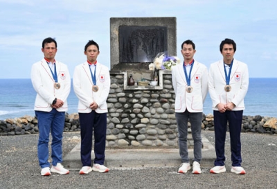 写真：硫黄島にある西竹一の碑の前で記念撮影する「初老ジャパン」の４人。右端は大岩義明選手＝１月、東京都小笠原村（日本馬術連盟提供）