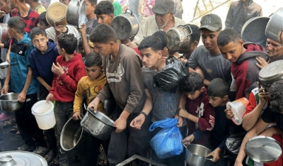 写真：１日、ガザで慈善団体による食料配給に並ぶパレスチナ人の子どもら（ゲッティ＝共同）