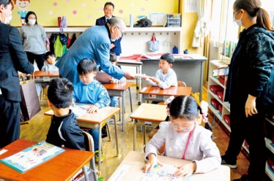 写真：横尾会長から啓発グッズを受け取る子どもたち