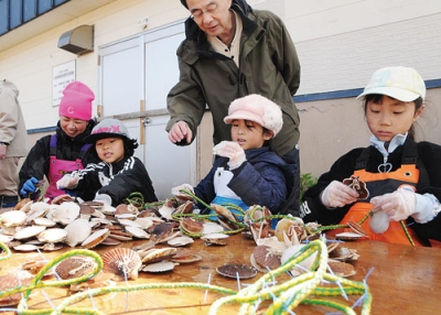 写真：黙々とホタテの耳づり作業を行う児童