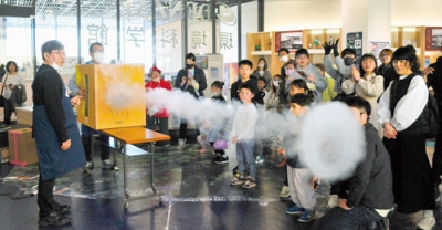 写真：巨大空気砲の実験で、空気の動きが分かる大きな白い輪の出現に見入る子どもたち