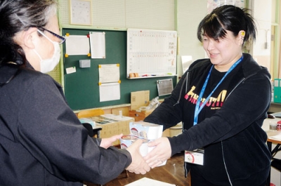 写真：絵鞆小縄文納豆を手渡す高橋広報課長（右）