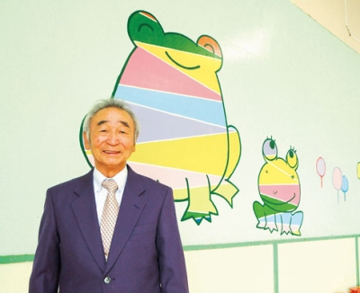 写真：今春勇退した小倉さん。後ろの壁面も自ら制作したという