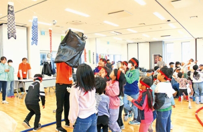 写真：丸めた新聞紙をビニール袋目がけて投げる子どもたち