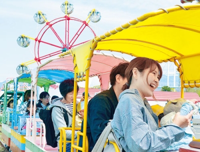 写真：水族館の豆汽車を楽しむ家族連れ