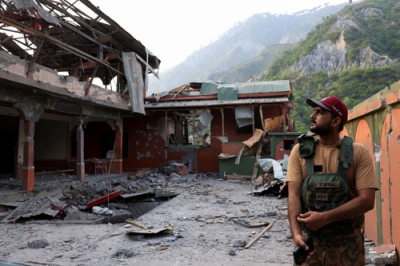 写真：７日、カシミール地方のパキスタン側支配地域で、インドの攻撃を受けたモスク近くに立つパキスタン兵（ロイター＝共同）