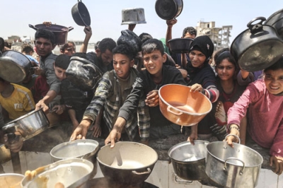 写真：７日、ガザ北部の避難民キャンプで、配給される食料を求める人たち（ゲッティ＝共同）