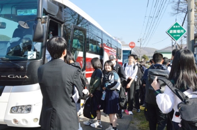 写真：バスに乗り出発する生徒たち