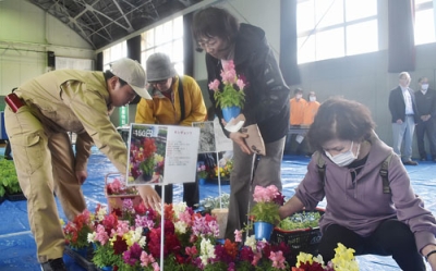 写真：花を求める来場者へ丁寧に説明する壮瞥高生（左）