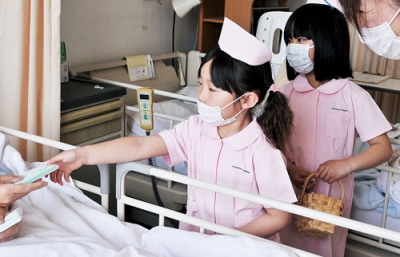 写真：「お大事に」と元気よく声をかけてティッシュを手渡す園児たち