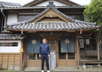 写真：社長を務める「あわえ」本社前に立つ吉田基晴さん＝徳島県美波町