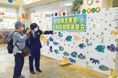 写真：反射材の効果を体験する来店者