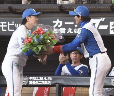 写真：連続救援登板のプロ野球記録を塗り替え、新庄監督（右）から花束を贈られる日本ハム・宮西＝エスコンフィールド