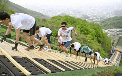 写真：札幌市の大倉山ジャンプ競技場で、ラージヒルを駆け上がる参加者＝１７日午前