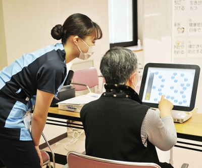 写真：看護師が見守る中、健康チェックを行う市民