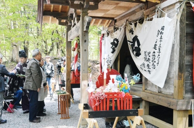 写真：プロジェクト関係者らにより修復した山神社で行われた神事