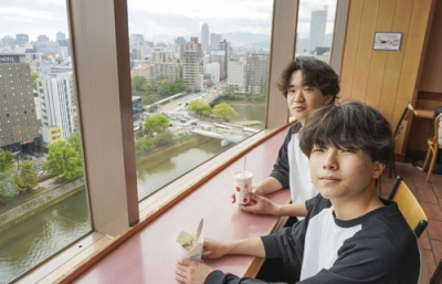 写真：日本で一番高層階に位置することが判明したマクドナルド「広島駅前福屋店」で食事する西村瑛公さん（奥）ら＝４月、広島市南区