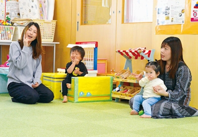 写真：講師の動きに合わせて手話歌を体験する親子たち