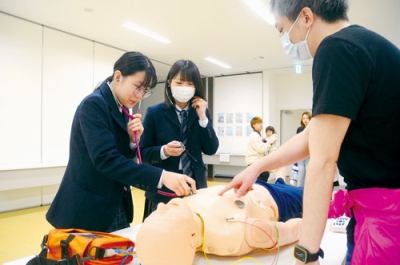 写真：聴診器で胸の音を聴く体験プログラムに参加する来場者